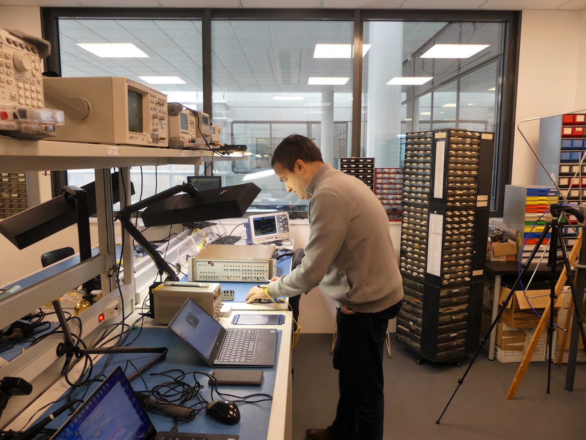 Jean-François à l'œuvre sur un plan de travail avec instruments de mesure